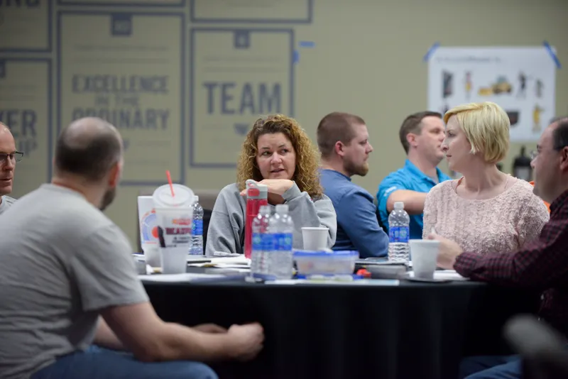 Private workshop participants discussing agile practices around a table